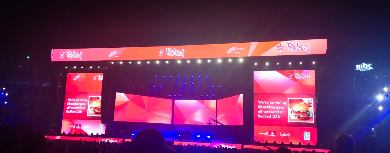 Bright red and orange stage backdrop with blue lights, featuring text about food and drink trading tips.