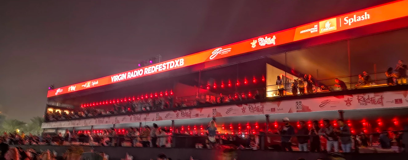 Vibrant red lighting illuminates the stage at Virgin Radio RedFestDXB in Dubai.