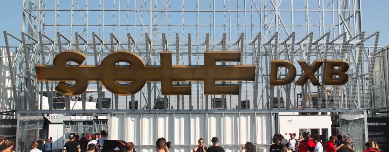 Large golden sign reading "SOUL" against a clear blue sky, with festival attendees in the foreground.