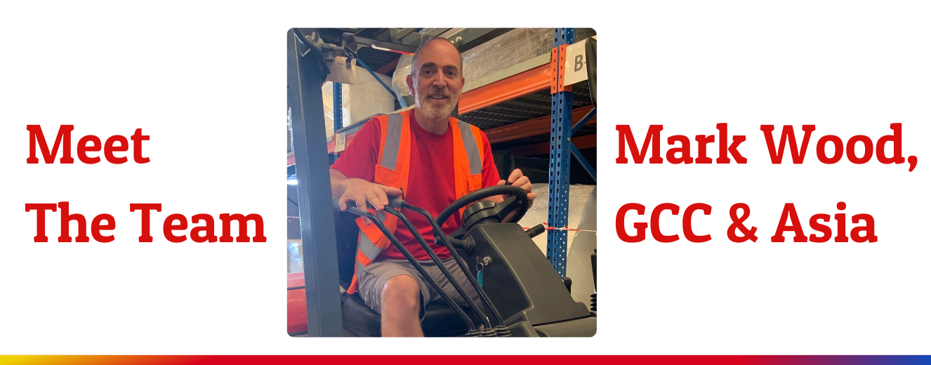 Mark Wood, Operations Director, sits on a forklift wearing a red shirt and orange vest.