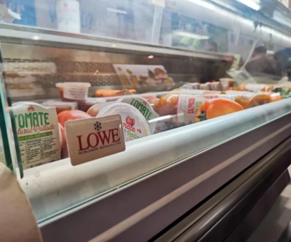Display of various packaged food items in a refrigerated case, featuring a prominent Lowe label.