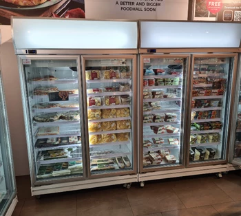 Three glass-fronted freezers filled with various packaged food items, set against a light background.