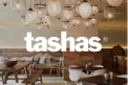 Interior of Tasha's featuring wooden furniture and stylish pendant lighting in a warm colour palette.
