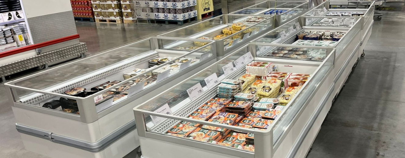 Frozen food displays filled with various packaged items, featuring bright colours and clear glass tops.