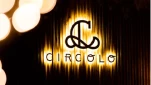 Stylised logo of "Circolo" in gold against a dark background with soft glowing lights.