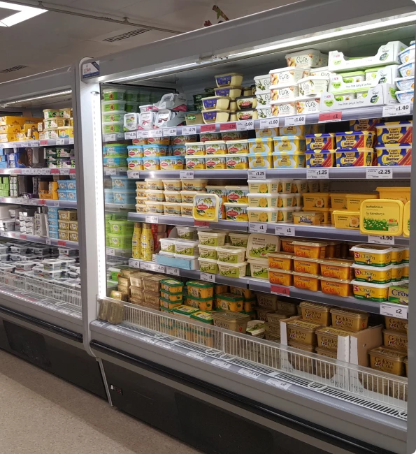 Refrigerated display showcasing various butter and margarine products in colourful packaging.