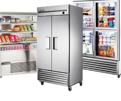 Stainless steel commercial refrigerator with double doors, surrounded by shelves of packaged food items.