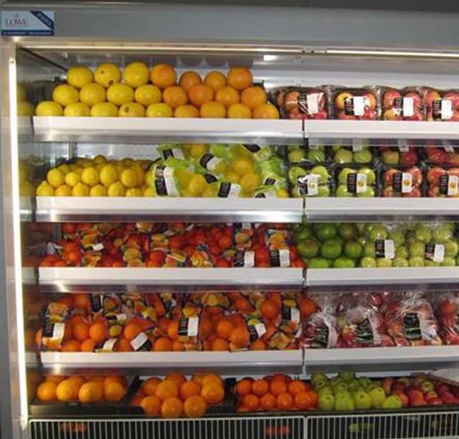 Vibrant display of assorted fruits, including oranges, apples, and grapes, in a refrigerated unit.