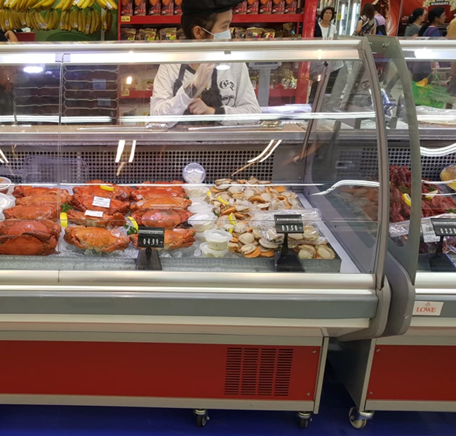 Chilled display case filled with various meats, featuring vibrant red and golden textures.
