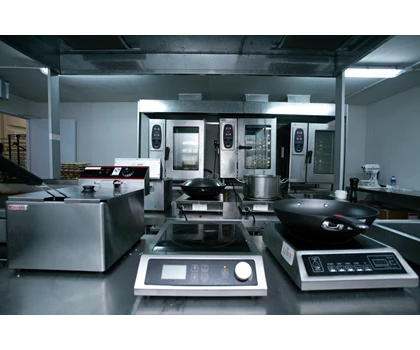 Modern kitchen equipped with stainless steel appliances and cooking stations, set for a culinary event.