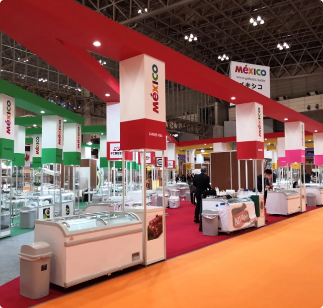 Brightly coloured exhibition hall featuring multiple food display units and signage for various vendors.