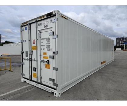 Large white shipping container with metal doors, set against a cloudy sky and concrete surface.