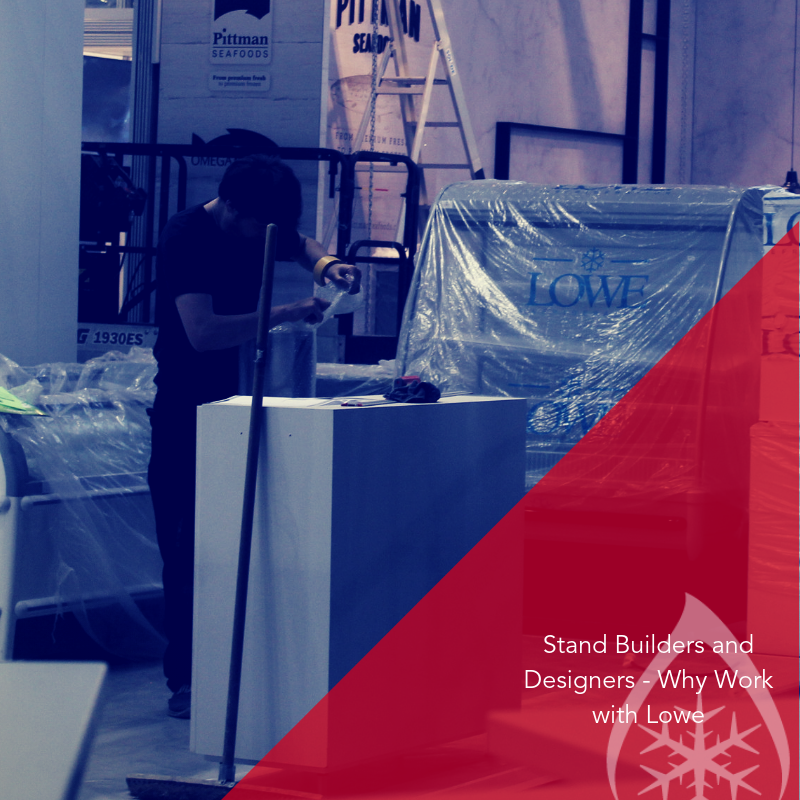 A worker in dark clothing prepares an exhibition stand amidst plastic-wrapped materials and equipment.