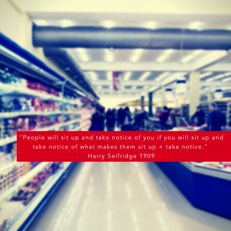 Brightly lit retail aisle with shelves stocked with products, featuring a prominent red quote banner.