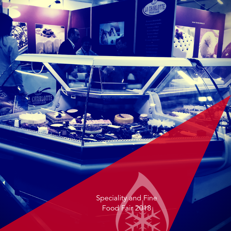 Display of assorted gourmet foods in a glass case, with a purple and red background.