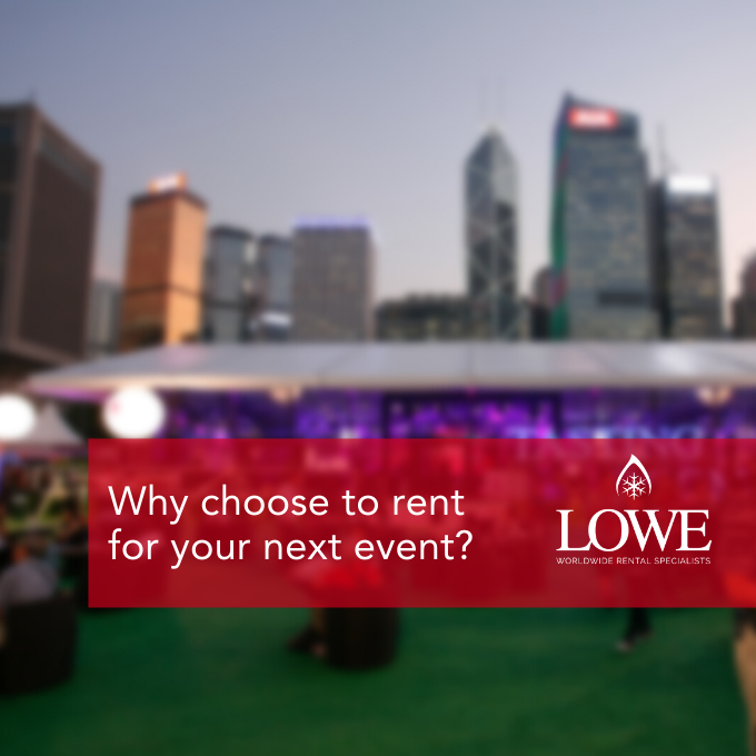 Event tent with purple lighting, green grass, and city skyline in the background.