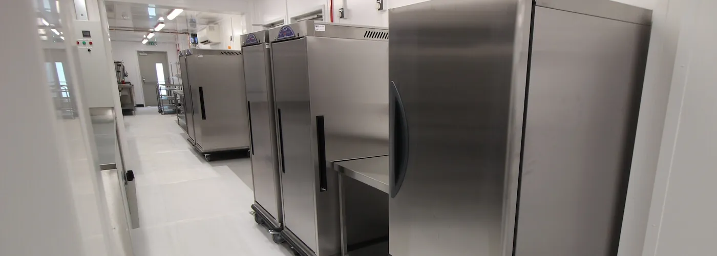 Stainless steel storage chillers lined up in a clean, well-lit commercial kitchen environment.