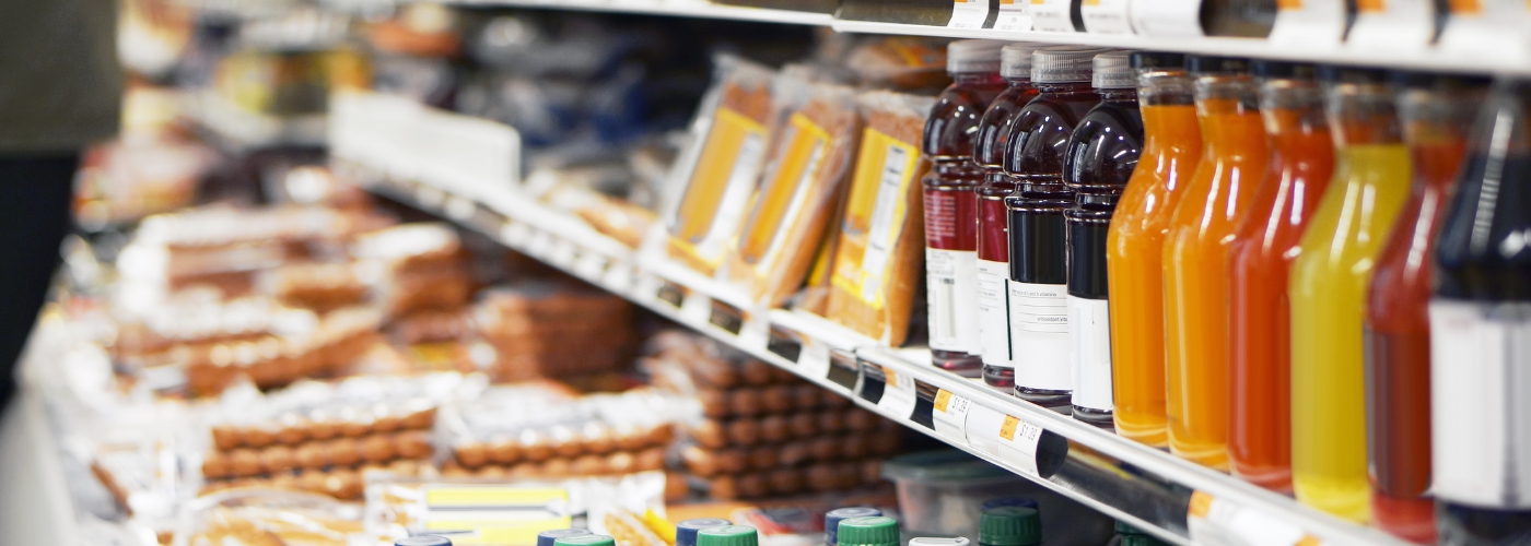 Shelves displaying various packaged foods, including yellow and red items, in a retail setting.