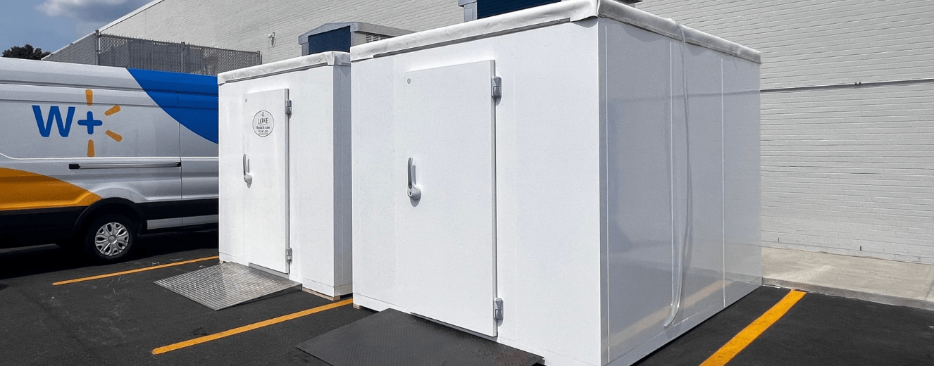 White temporary refrigeration units lined up, featuring metal doors and a smooth, clean surface.