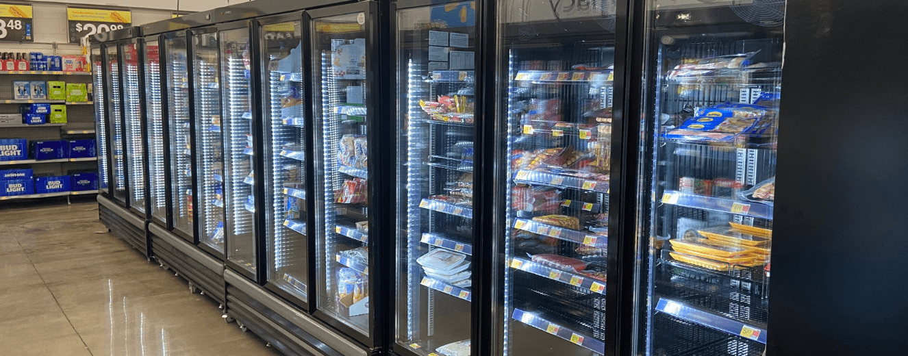 Refrigeration units displaying various packaged food items, illuminated with bright LED lights.