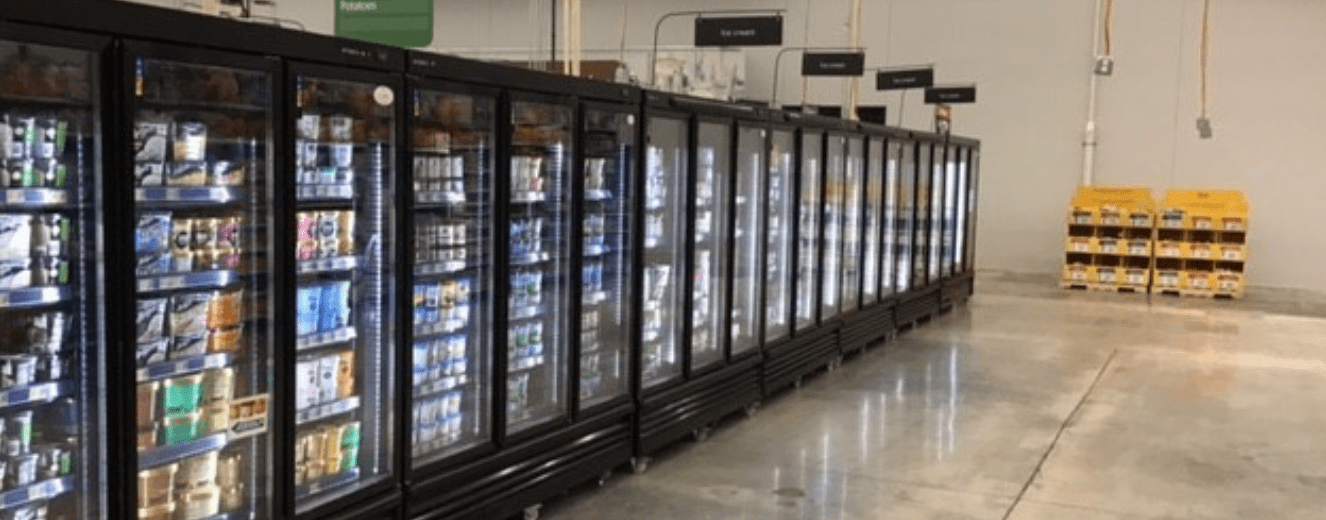 Black refrigerated display units lined up, showcasing various products in a well-lit store aisle.