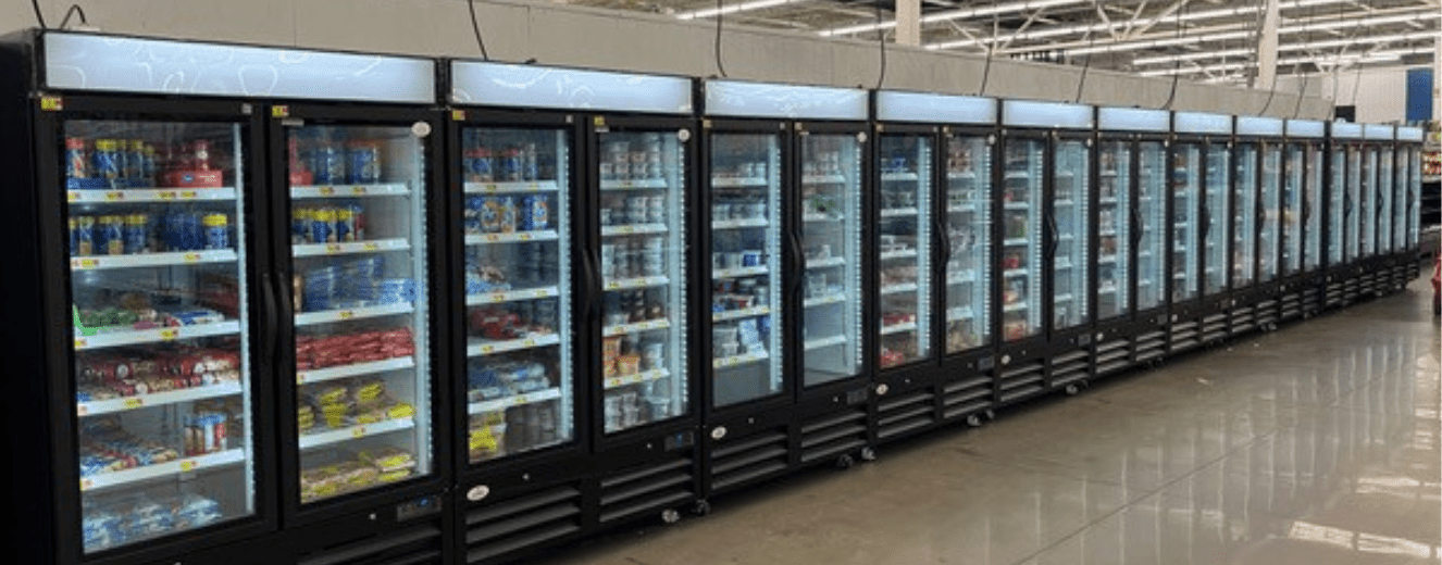 Black refrigerated display units with glass doors, showcasing various products in a store setting.