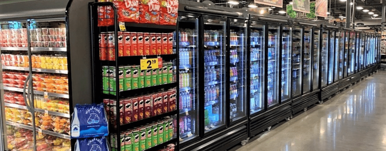 Refrigerated display cases filled with colourful beverages, alongside shelves of snacks in bright packaging.