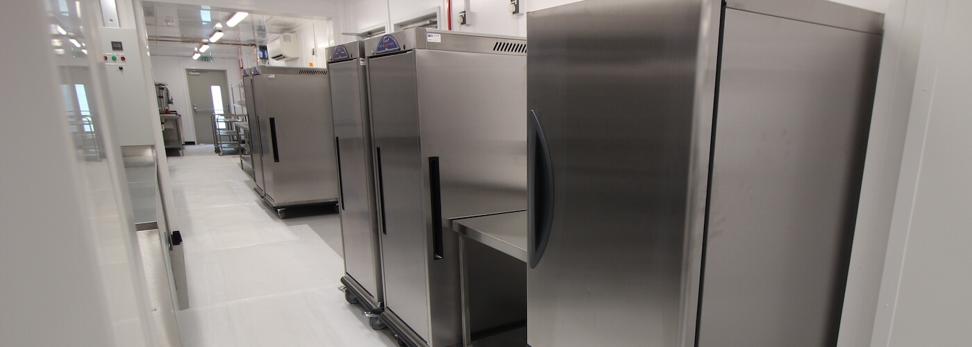 Stainless steel storage chillers lined up in a clean, well-lit environment.