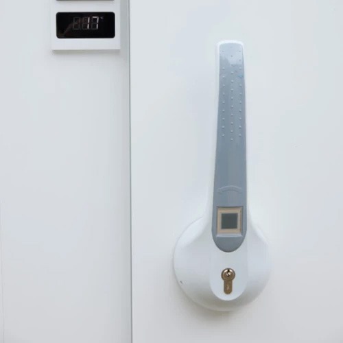 White walk-in cooler door with a silver handle and digital temperature display.