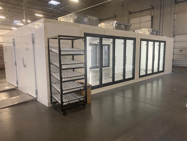 Cold storage rooms with built-in glass doors, featuring a black metal shelving unit in foreground.