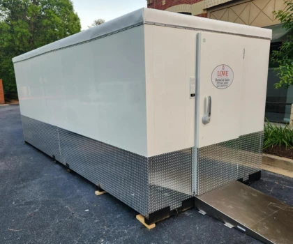 White emergency storage unit with a silver base, positioned on a paved surface.